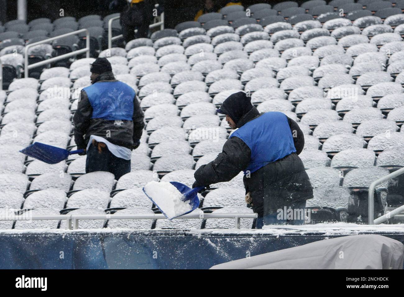 Workers at Soldier Field clear snow from the stands before an NFL football game between the Chicago Bears and New England Patriots in Chicago, Sunday, Dec. 12, 2010. (AP Photo/Charles Rex Arbogast