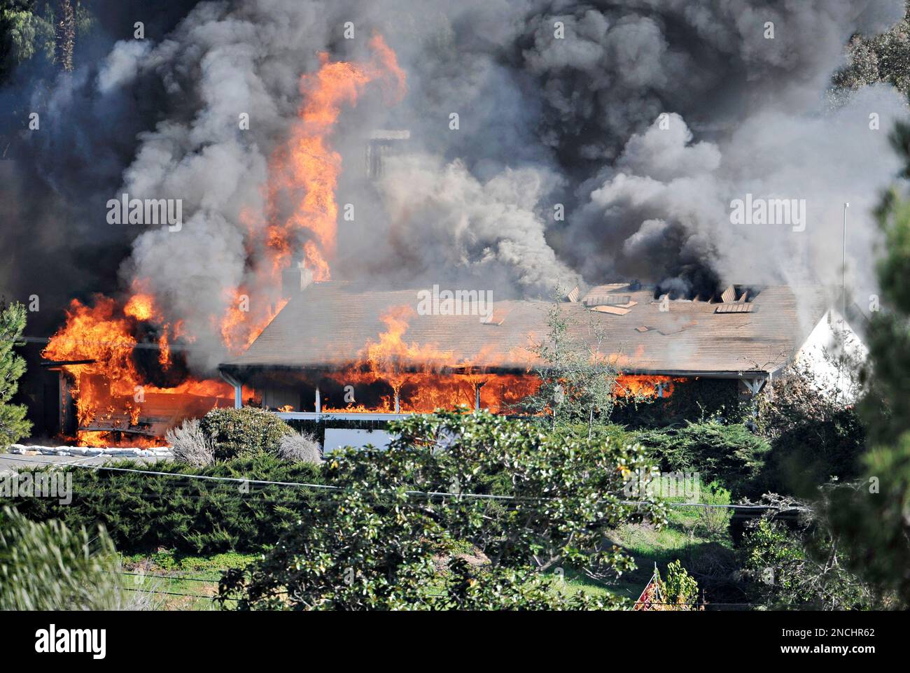 A house is enveloped in flames on Thursday, Dec. 9, 2010 during 