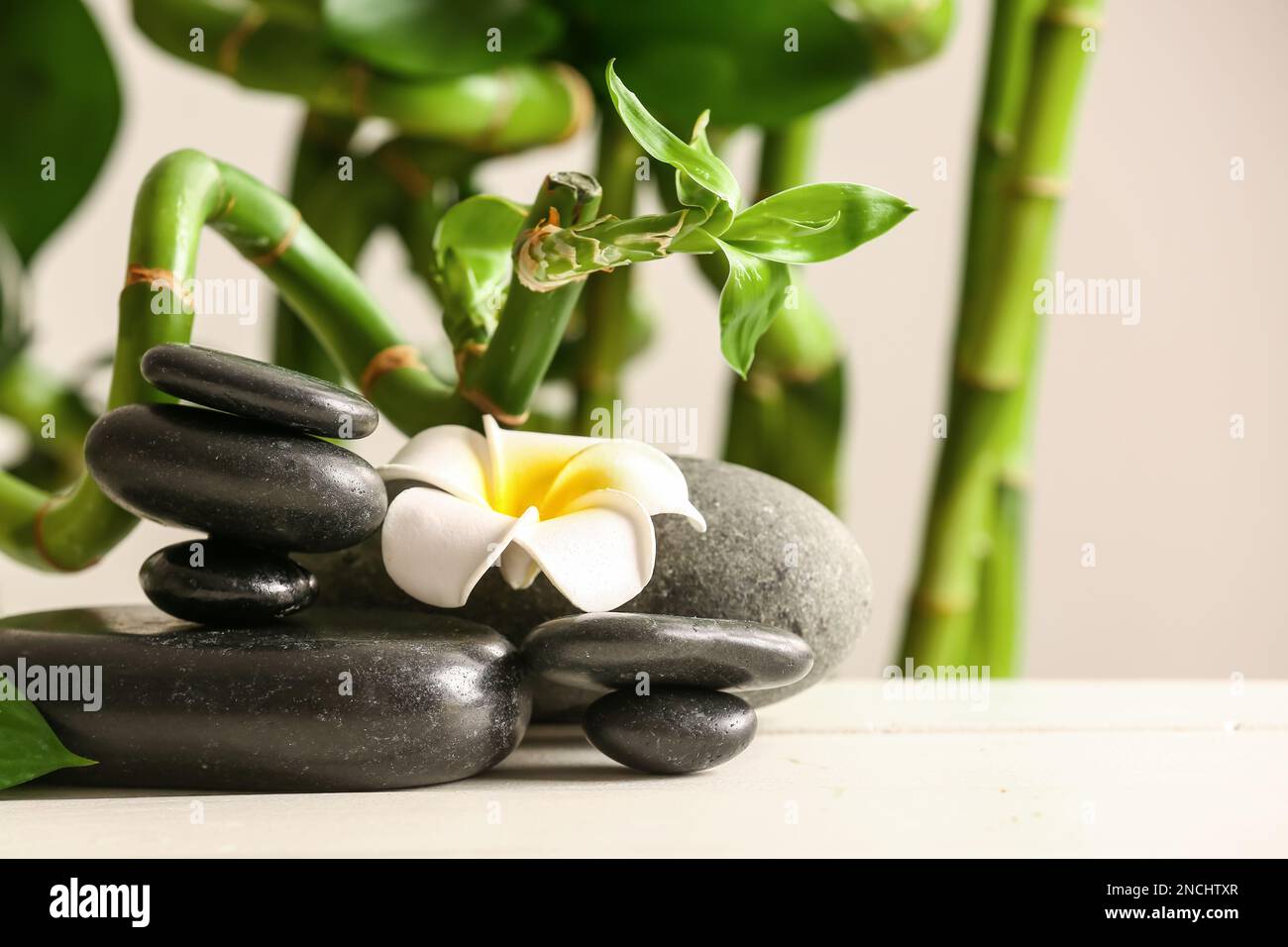 Spa stones, flower and bamboo on light background Stock Photo - Alamy