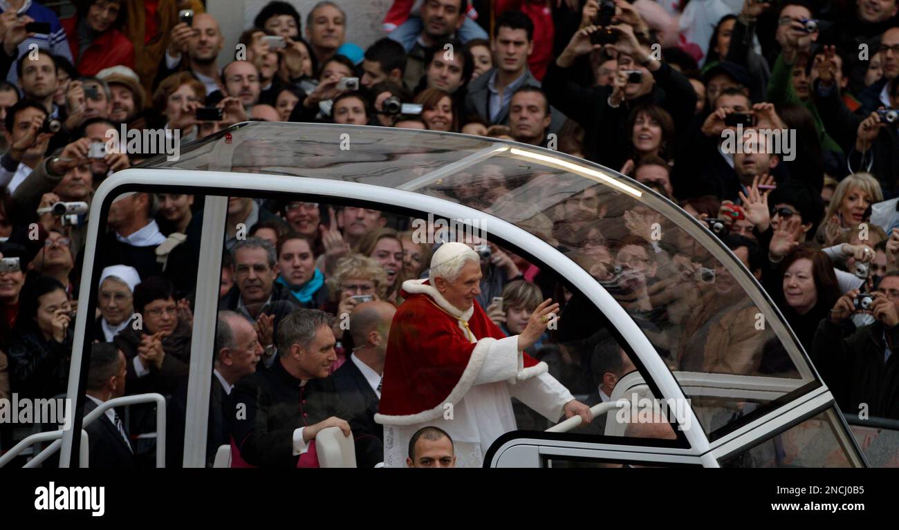Pope Benedict XVI waves from his popemobile as he arrives for the ...