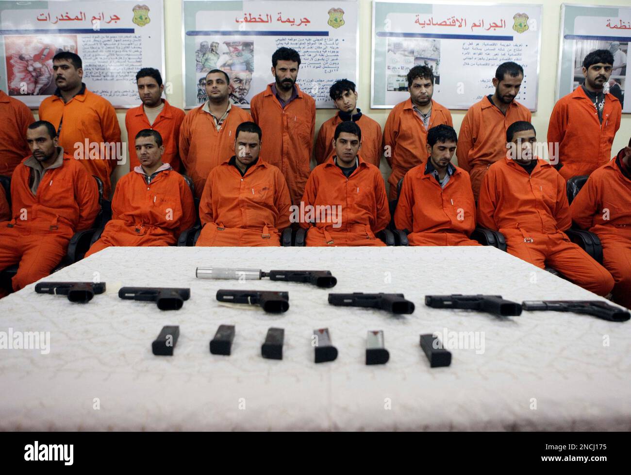 Handcuffed suspected terrorist are seen next to their weapons in the