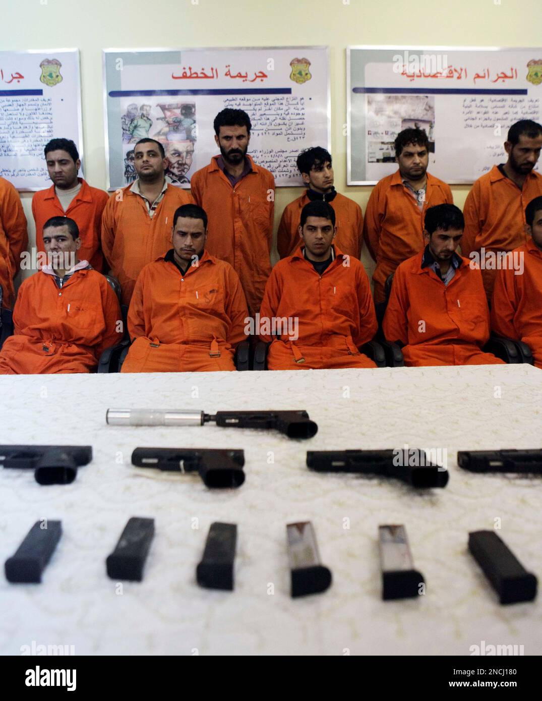 Handcuffed suspected terrorist are seen next to their weapons in the