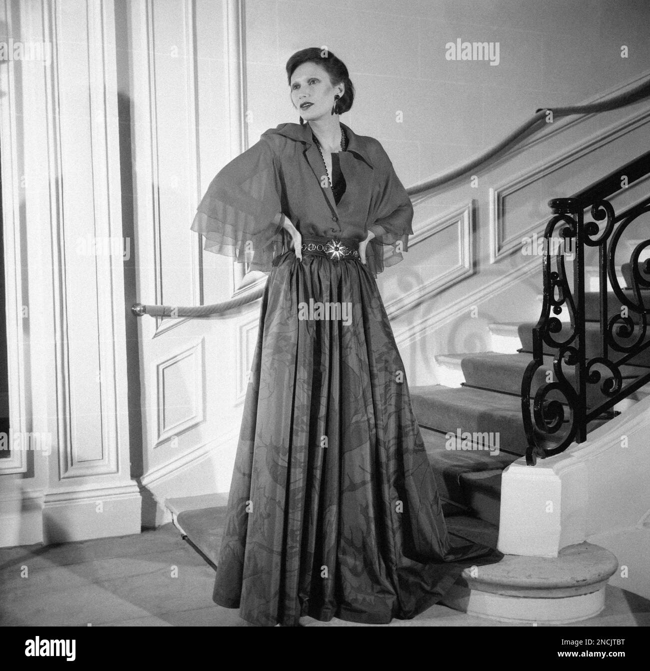Paris Christian Dior Fashion house presents the 1974 spring and Summer  collection, Aug. 2, 1974. A model wears this long evening dress with a  chemise top in red silk chiffon widely opened
