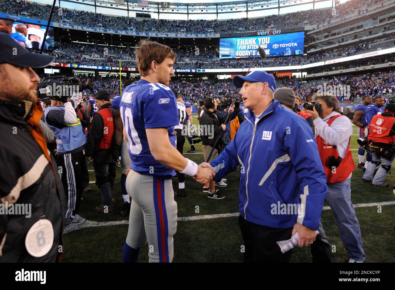 New York Giants' head coach Tom Coughlin, right, shakes hands with quarterback Eli Manning after