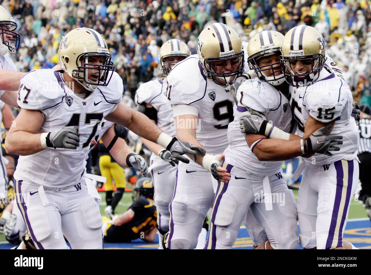 Washington running back Chris Polk, second from right, is mobbed 