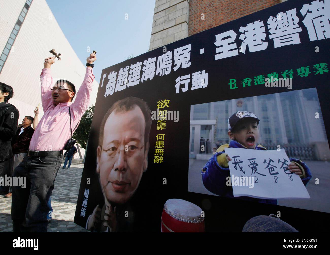 Pro-democracy protesters play music instruments and make loud voice in front of the picture of Zhao Lianhai with the Chinese words reading "To cry for redress an injustice for Zhao Lianhai, screams pierce the sky in Hong Kong" during a demonstration in Hong Kong Saturday, Nov. 27, 2010. The Chinese father-turned-activist imprisoned for protesting a tainted milk scandal is seeking medical parole, in what might be a deal with authorities hoping to tamp public anger over his harsh sentence. (AP Photo/Kin Cheung) Stock Photo