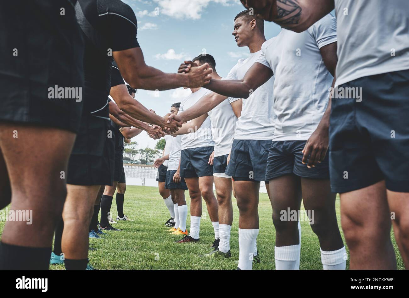 Well played. a group of young rugby players shaking each others hands to congratulate in playing a good game outside on a filed. Stock Photo
