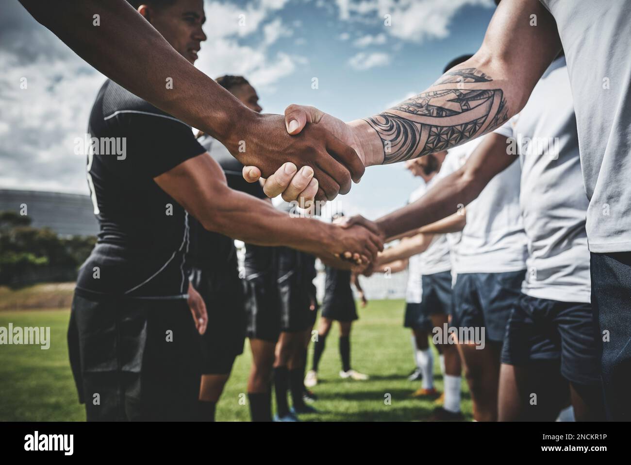 Thanks for a great game. a group of young rugby players shaking each others hands to congratulate in playing a good game outside on a filed. Stock Photo