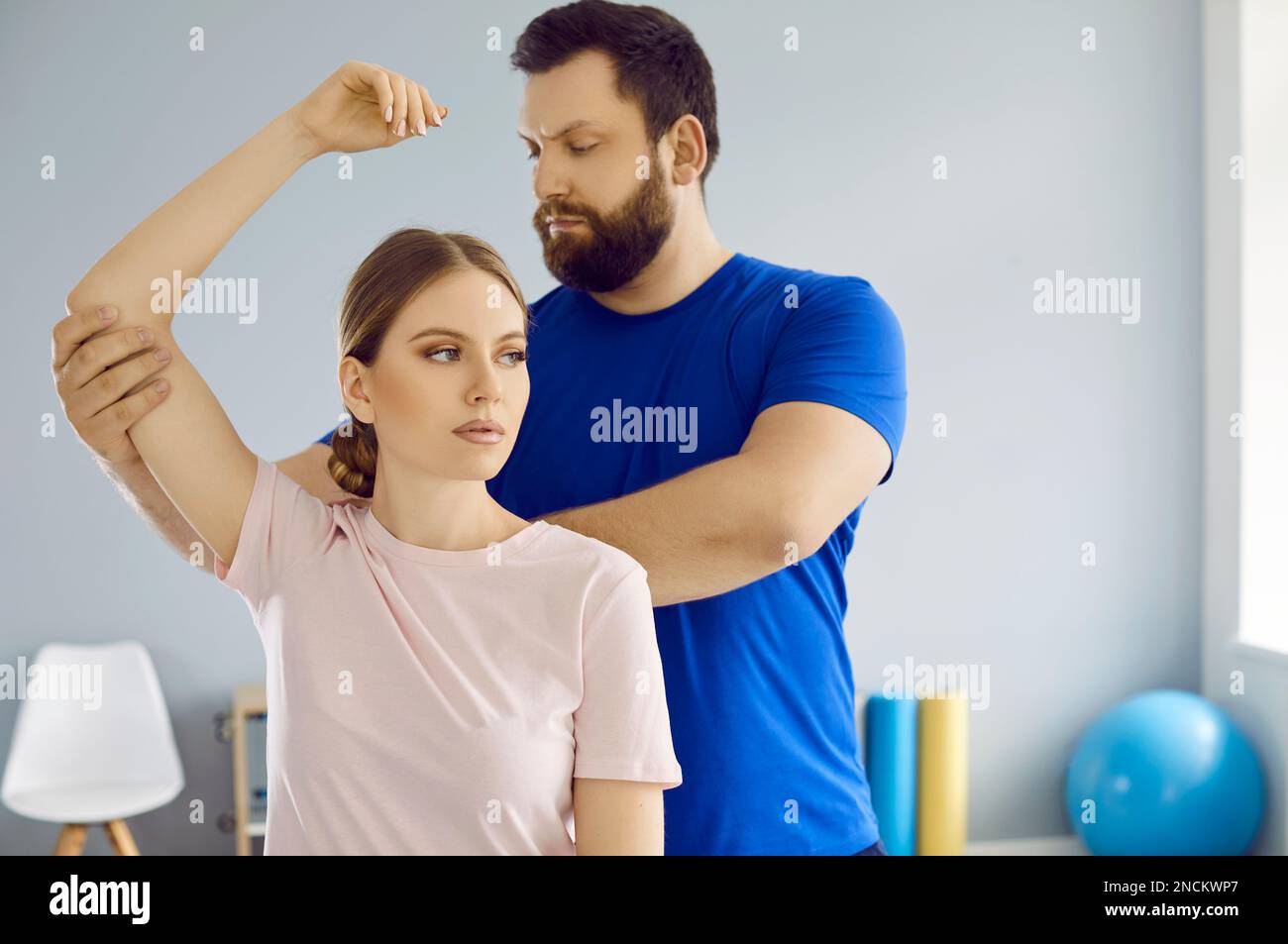 Osteopath masseur kneads joints of young woman's hands during treatment