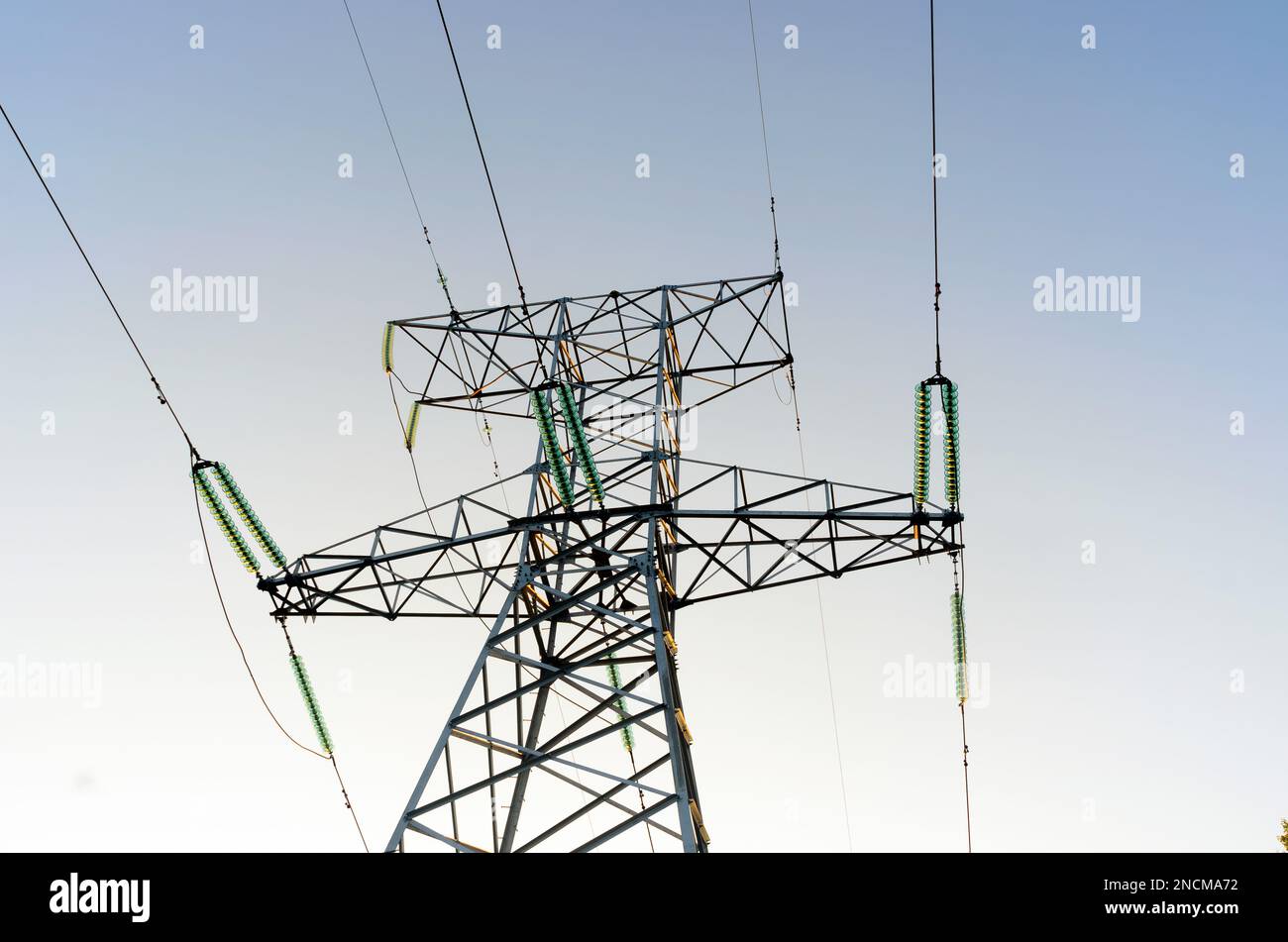 The tip end anchor metal supports of overhead power lines costs with wires and bundles of strands of high-voltage insulators against Stock Photo