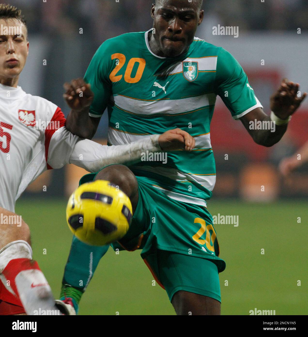 Poland's Adam Matuszczyk , left, is challenged by Guy Demel of Ivory
