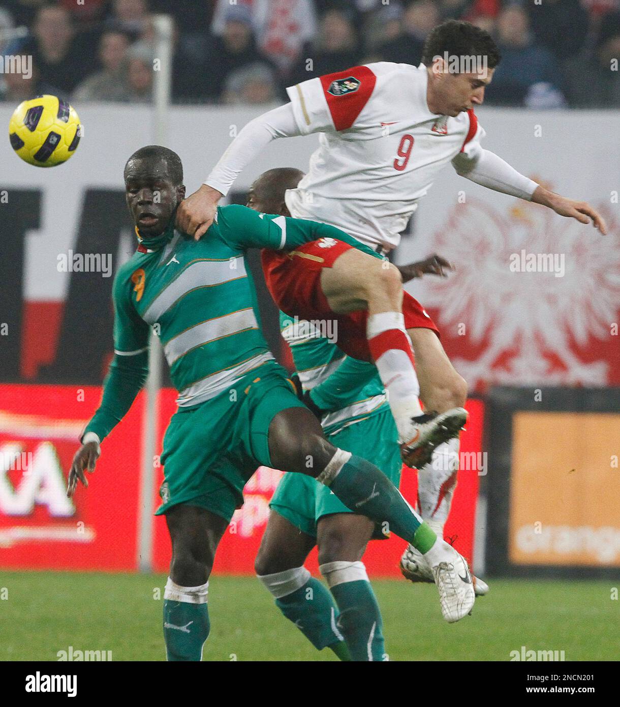 Poland's Robert Lewandowski , right, is challenged by Cheick Tiote of ...