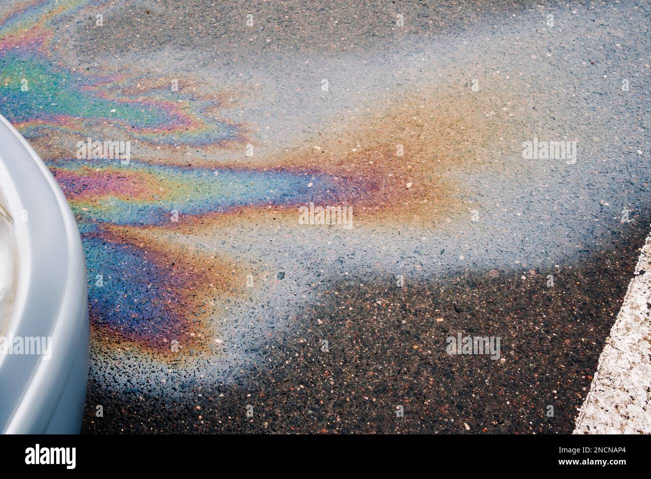 Oil stain or gasoline caused by a leak under a car. Environmental