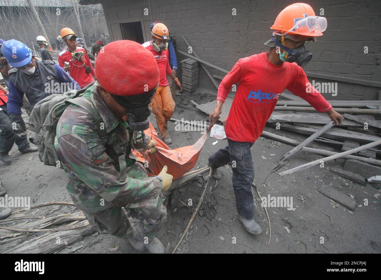 Indonesian soldiers and volunteers carry the body of a victim Mount ...