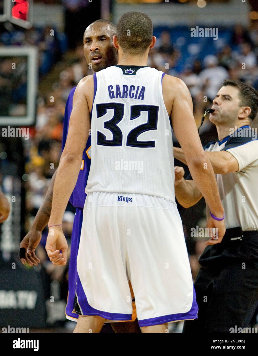 Referee Eli Roe, right, separates the Los Angeles Lakers' Kobe Bryant,  left, and the Sacramento Kings' Francisco Garcia, center, after Garcia  fouled Bryant late in the second half in Sacramento, Calif. on