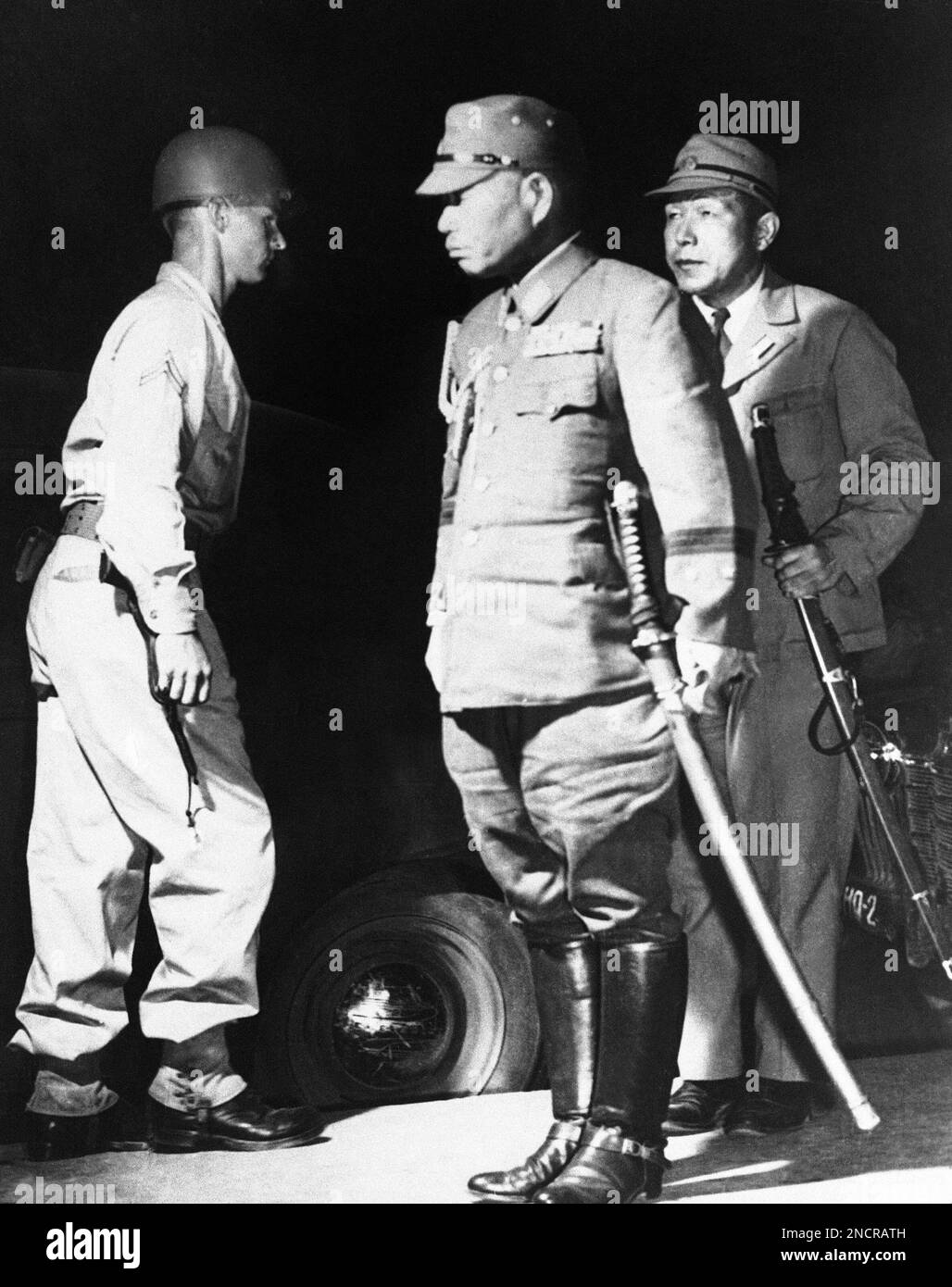 Lieutenant General Takashoro Kawabe, center, Vice Chief of the Japanese Imperial Staff and head of the Japanese Surrender Arrangement Delegation, wearing his sword, arrives at General Headquarters in Manila, on Aug. 31, 1945 to present credentials from Emperor Hirohito. (AP Photo) Stock Photo