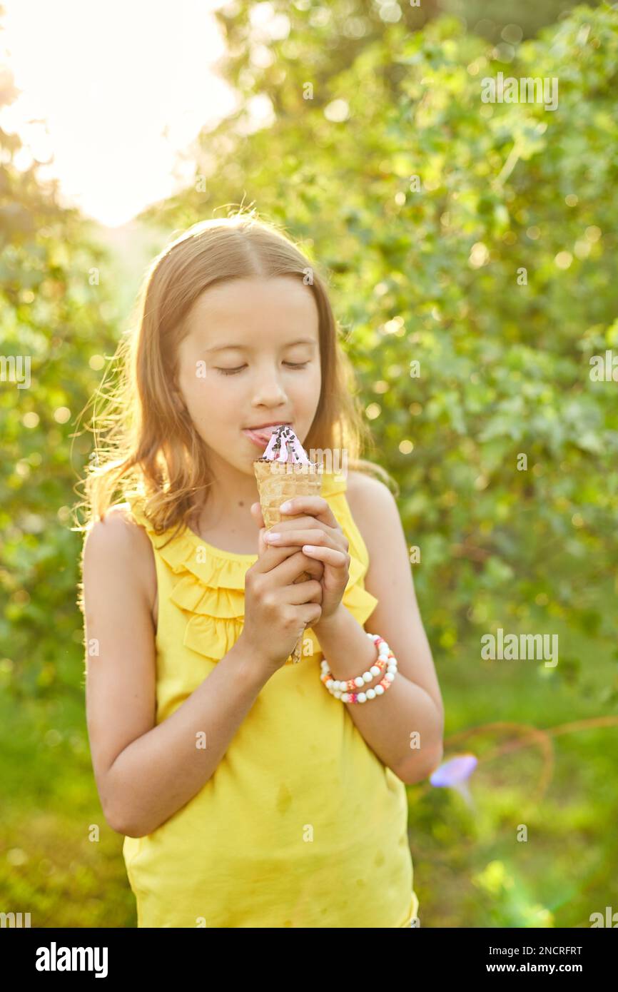 Happy girl with braces eating italian ice cream cone smiling while