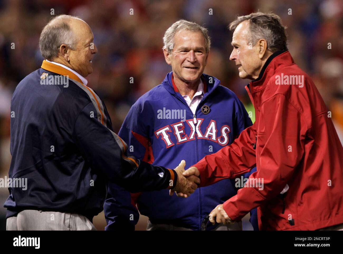 Former Presidents George Bush, right, and his son, George W. Bush shake ...