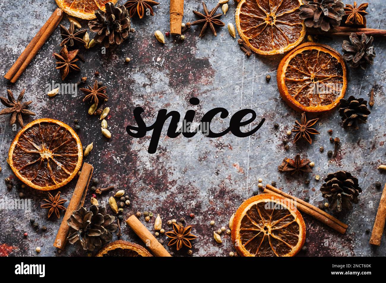 Cinnamon, cloves, pepper, dried oranges anise grey background. Frame