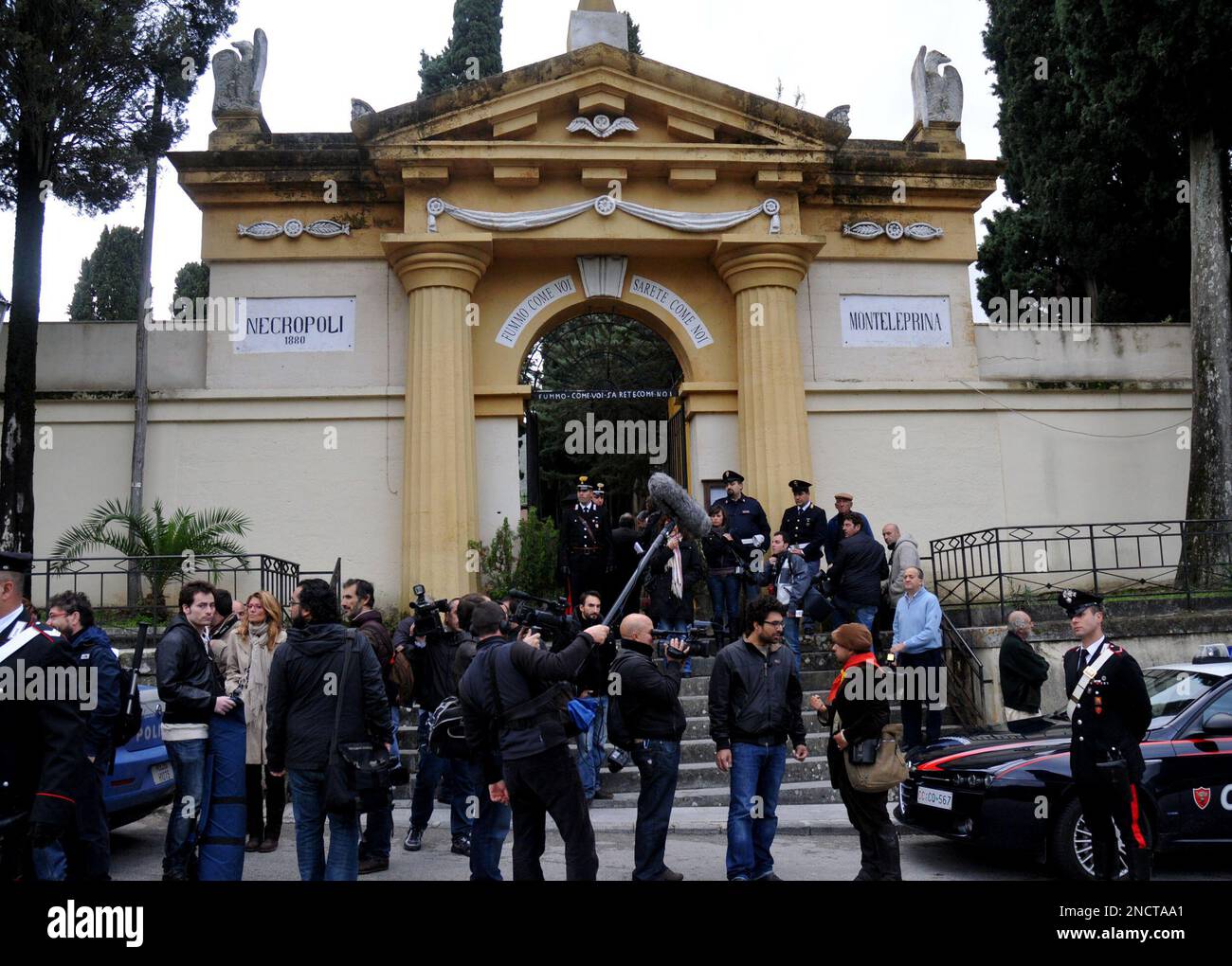 Reporters stand in front of Montelepre Cemetery, during the exhumation of the presumed body of the legendary Sicilian bandit Salvatore Giuliano. in Montelepre, near Palermo, Southern Italy, Thursday, Oct. 28, 2010. Authorities in Sicily have exhumed the presumed body in an attempt to put to rest doubts the corpse isn't that of the outlaw who terrorized the island's countryside in the 1940's. For decades doubts swirled over whether the body, riddled with bullet holes and buried 60 years ago, was Giuliano's, feeding theories the bandit was not killed but had escaped. Sicilian historian Giuseppe  Stock Photo