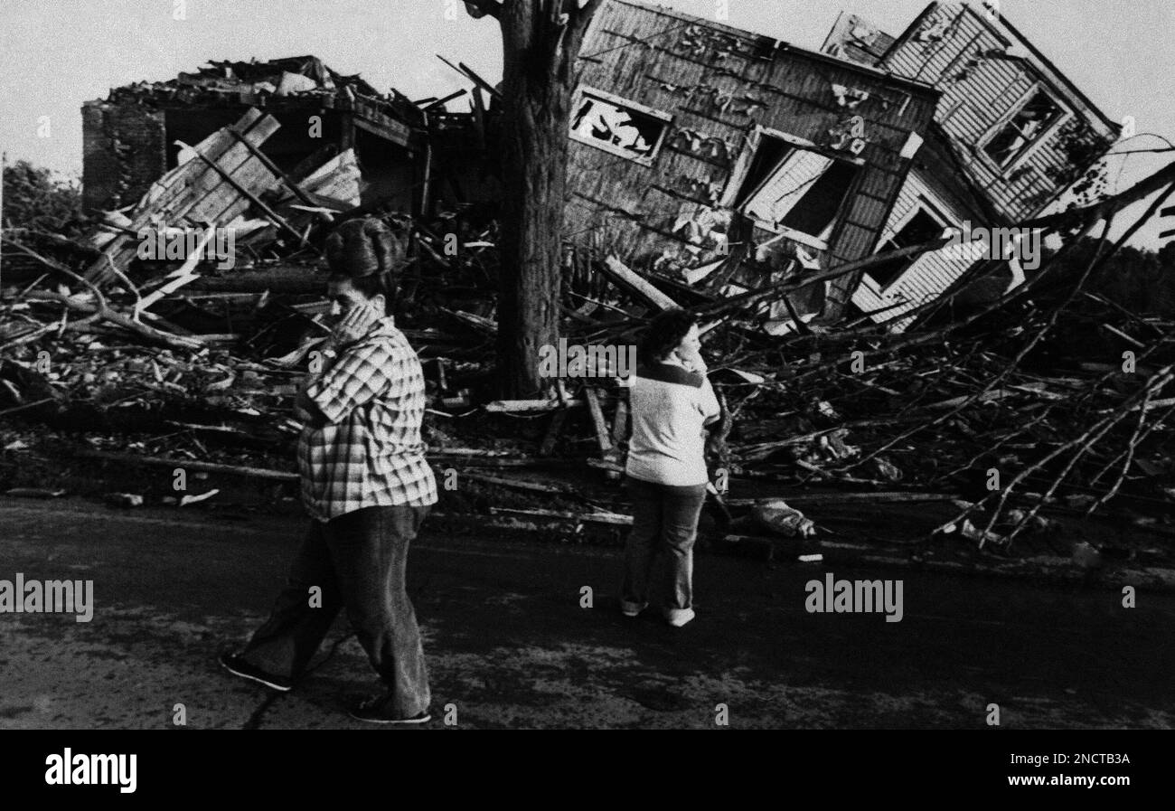Two women view the destruction of a few of the homes that were
