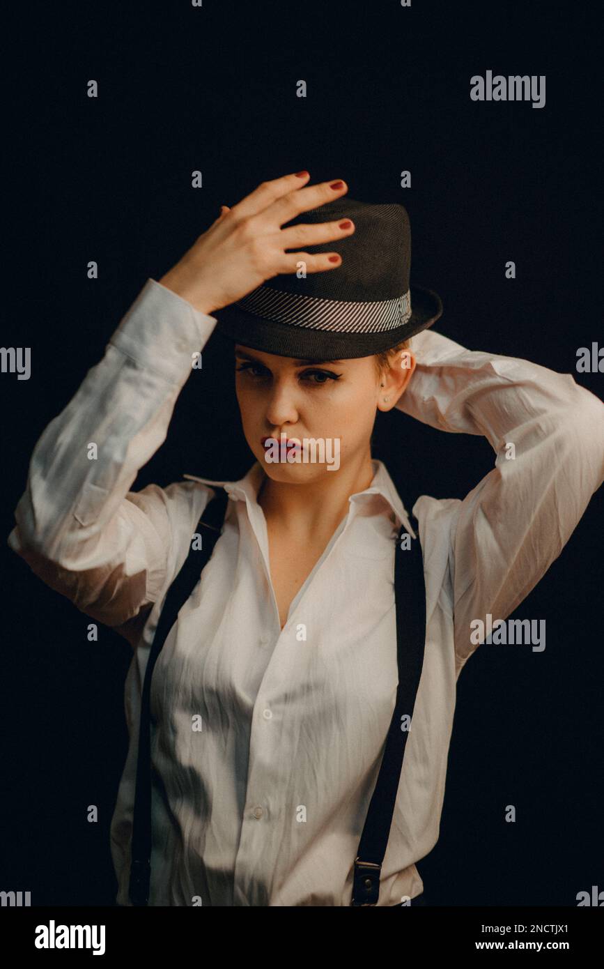 portrait of girl white shirt with suspenders and red lipstick in hat