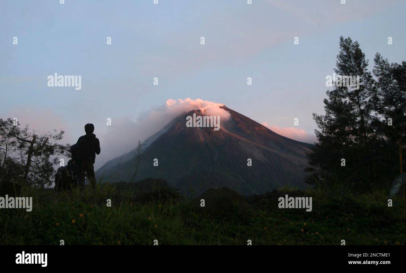 A villager watches Mount Merapi in Kaliadem, Yogyakarta, Indonesia ...