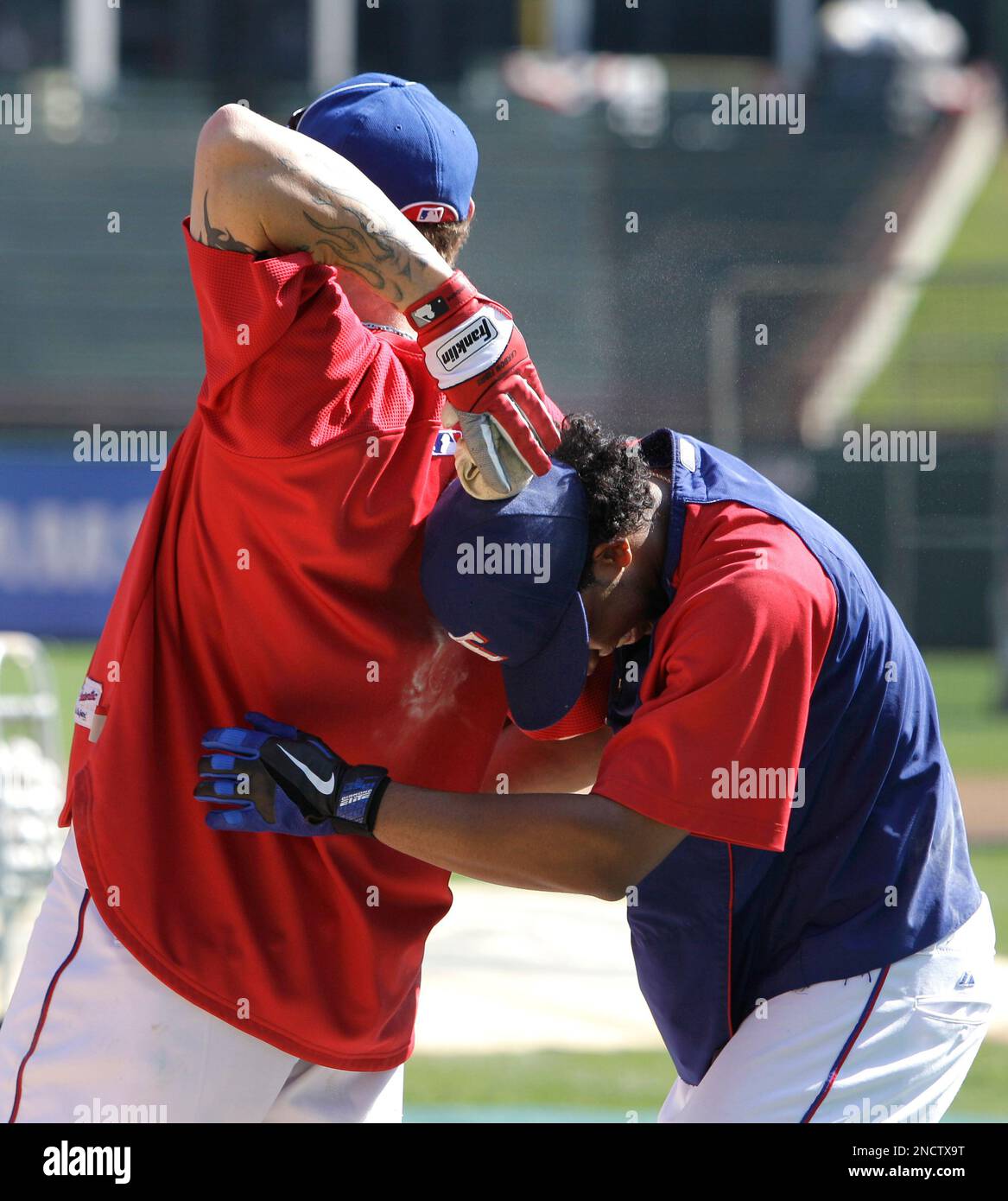 Texas Rangers' Josh Hamilton, left, reaches back to hit Elvis Andrus,  right, on the head with a rosin bag as the two joke around during a  baseball team practice for the World