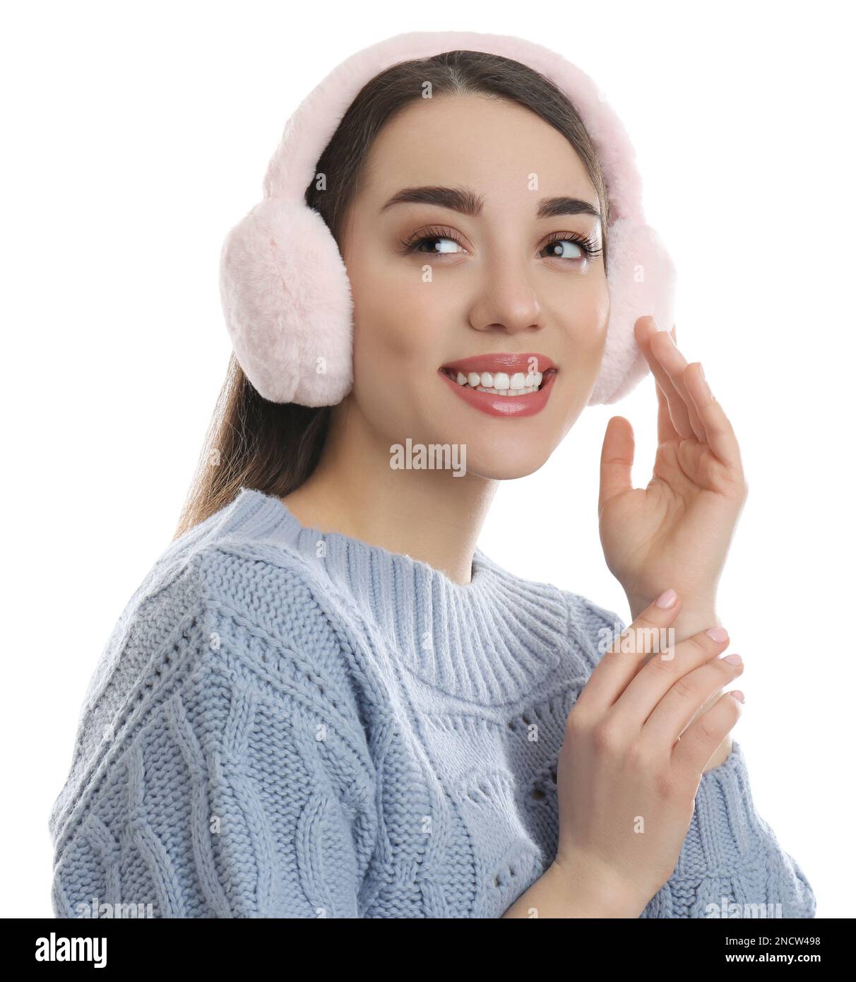 Beautiful young woman wearing earmuffs on white background Stock Photo