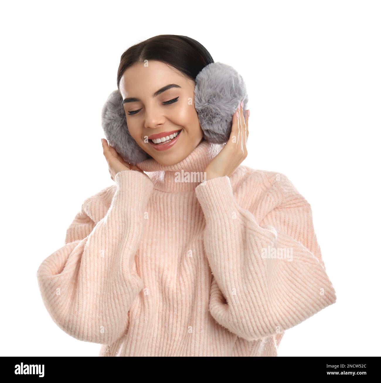 Beautiful young woman wearing earmuffs on white background Stock Photo