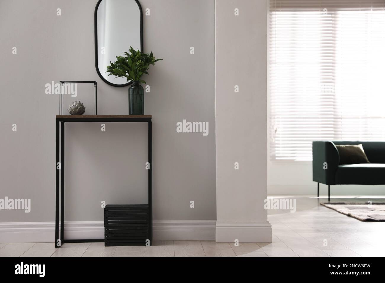 Console table with decor and mirror on light wall in hallway. Interior ...