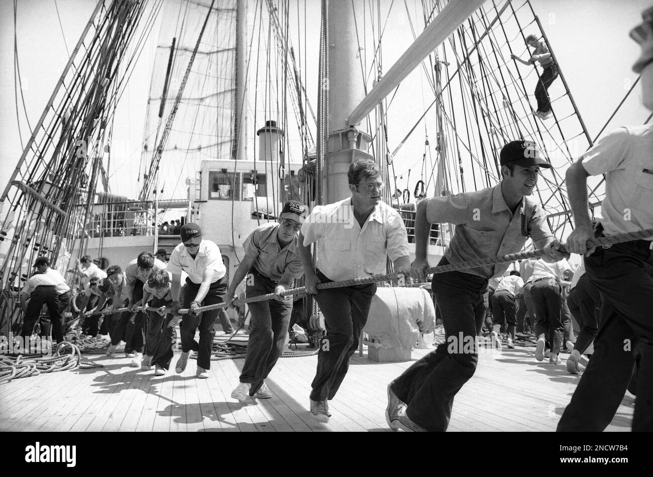 Cadets aboard the U.S. Coast guard academy training ship Eagle haul a line across the deck of