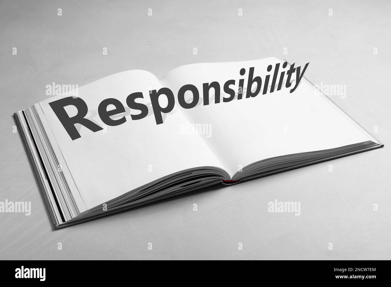 Roles and Responsibility concept. Open book on light grey table Stock