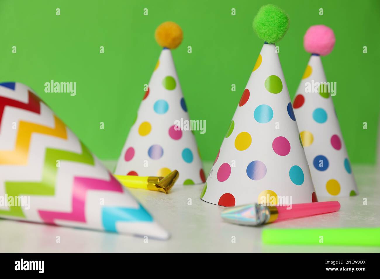 Birthday party hats and horns on light table Stock Photo - Alamy