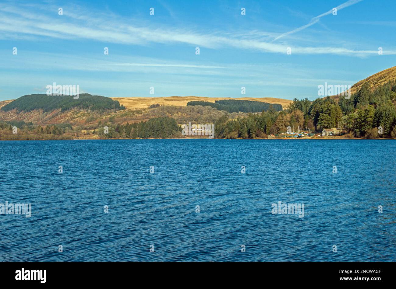 Pontsticill Reservoir in the Brecon Beacons with the Boathouse and woods and trees clearly visible on a sunny Spring day. Stock Photo