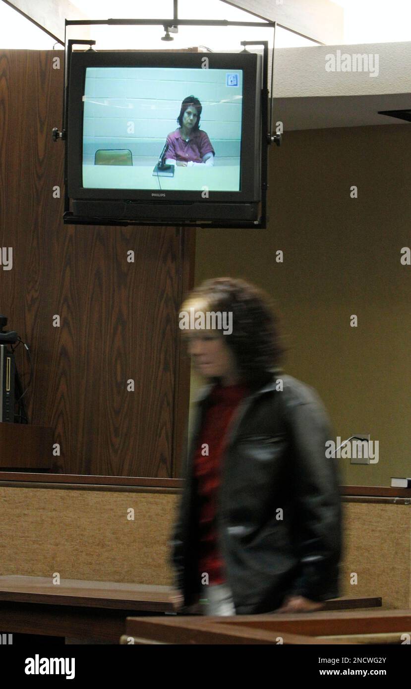 Elisa Baker, on video screen, looks on as her daughter Amber Fairchild, bottom, walks away after