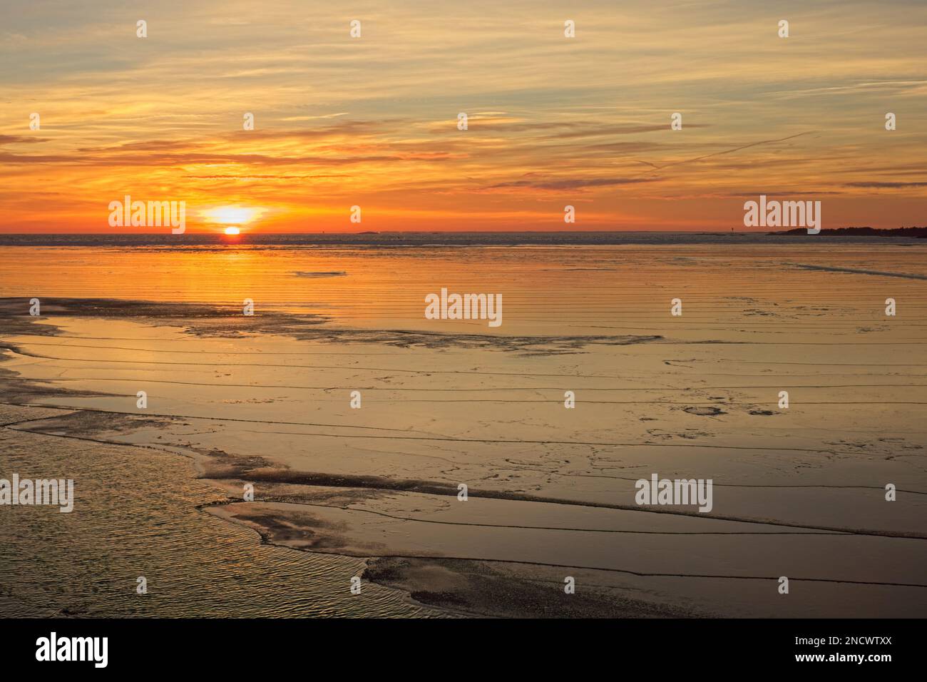 Sunset at Porkkalanniemi on seashore with sea frozen and sky reflecting on ice in winter , Kirkkonummi, Finland. Stock Photo