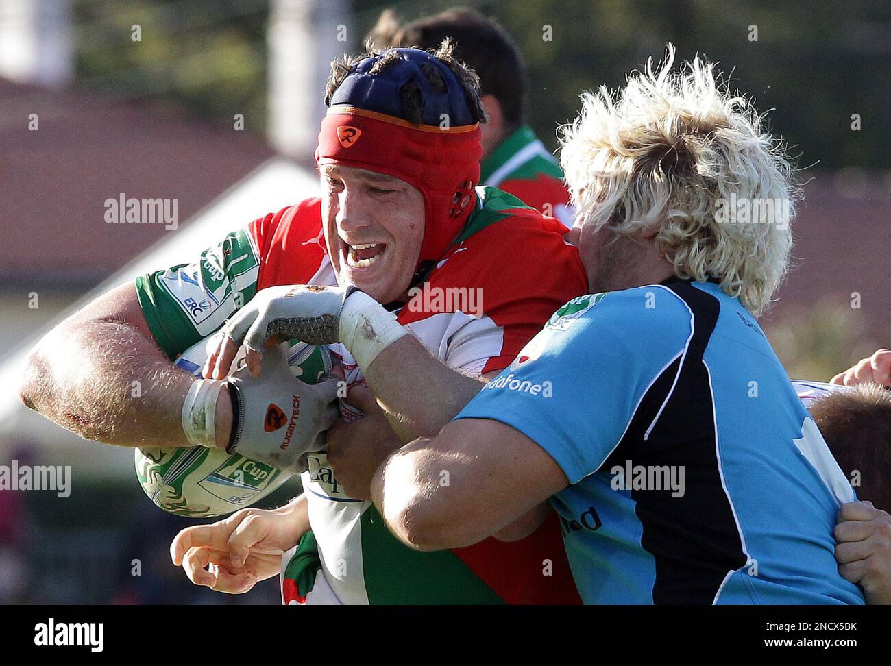 Biarritz's Jerome Thion is tackled by Ulster's player during their ...