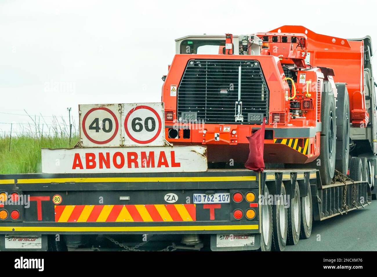 Abnormal truck load with a heavy vehicle or machine on a trailer in South Africa concept transport and industry Stock Photo