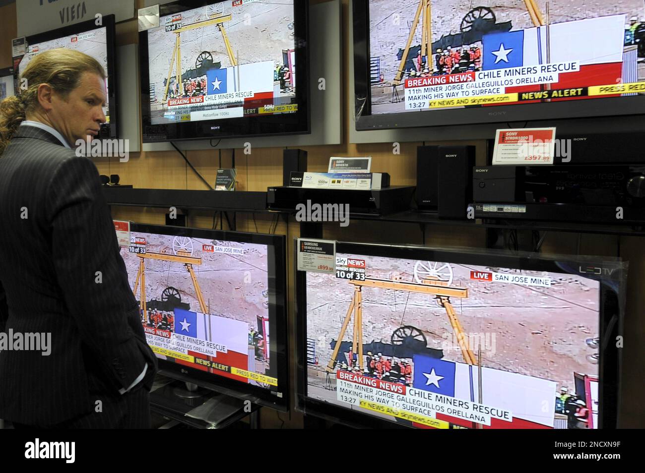 Customer Alan Frame stands in front of television screens showing the