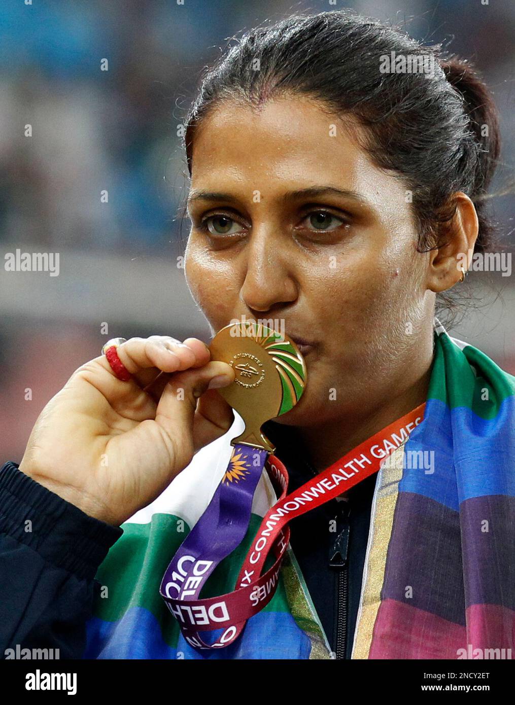 India's Krishna Poonia poses with her gold medal for the Women's Discus