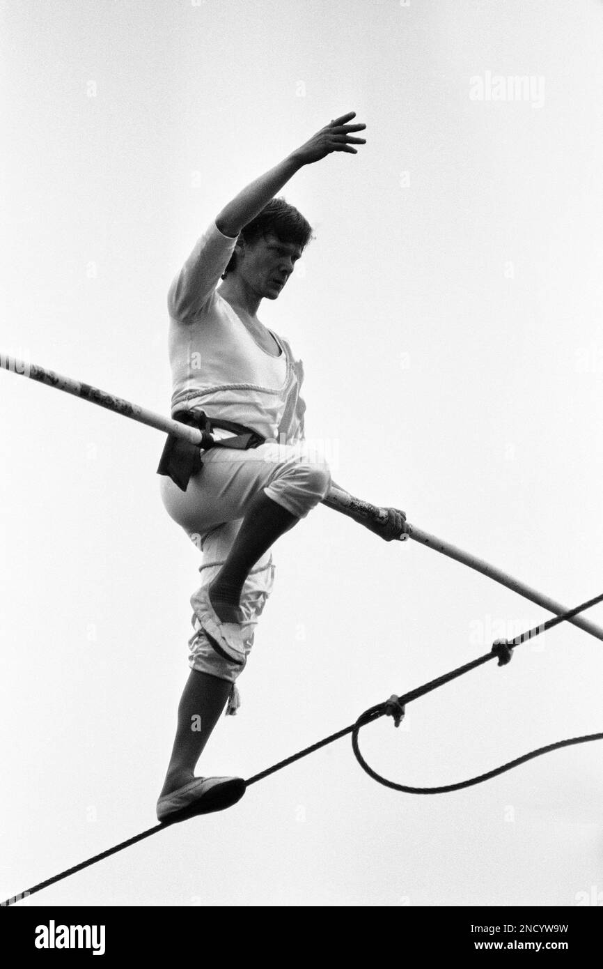 French tightrope walker Philippe Petit poses in a balance as he walks on a cable wire between