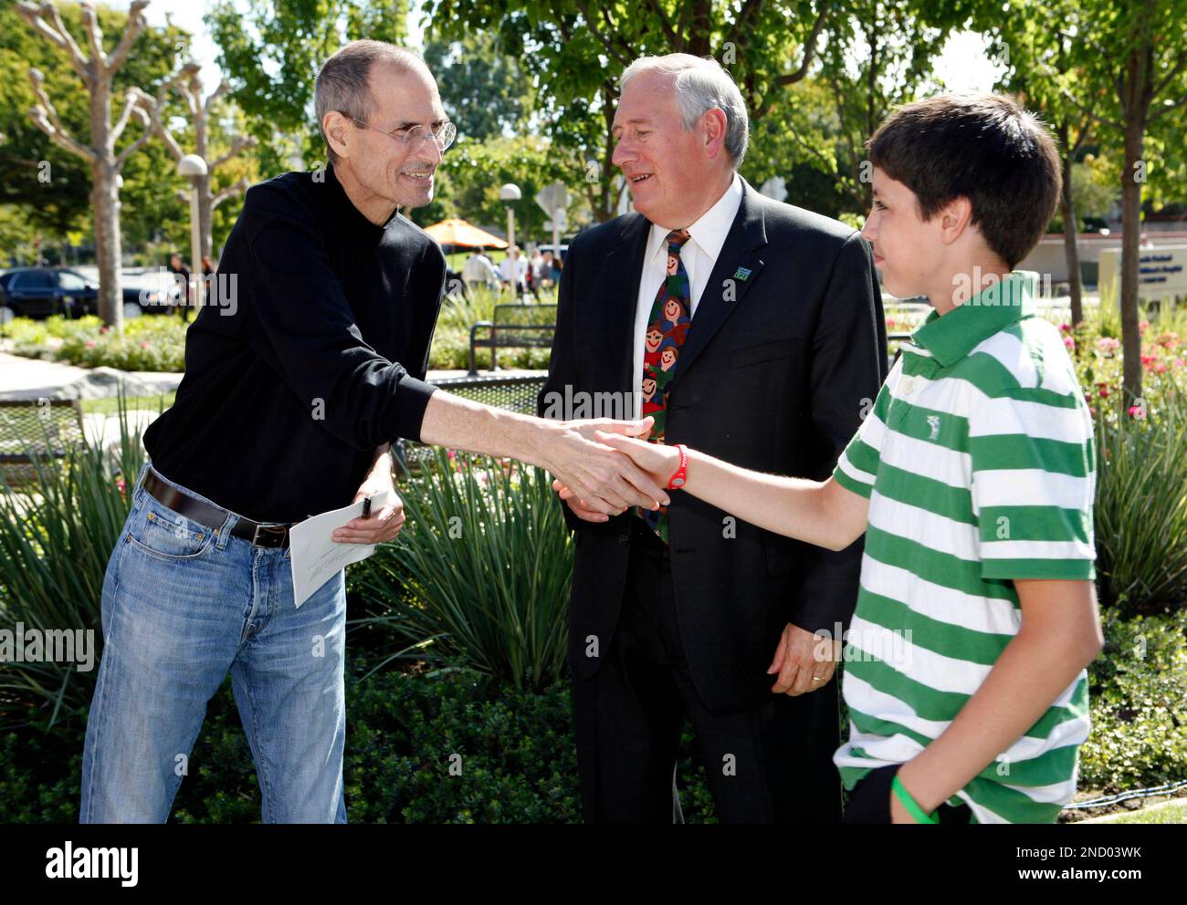 Apple CEO and cofounder Steve Jobs, left, shakes hands with Connor