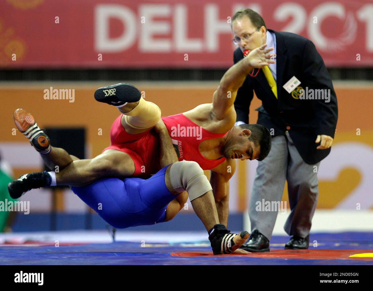 Pakistan's Muhammad Ali, in red, challenges with Australia's Hassan