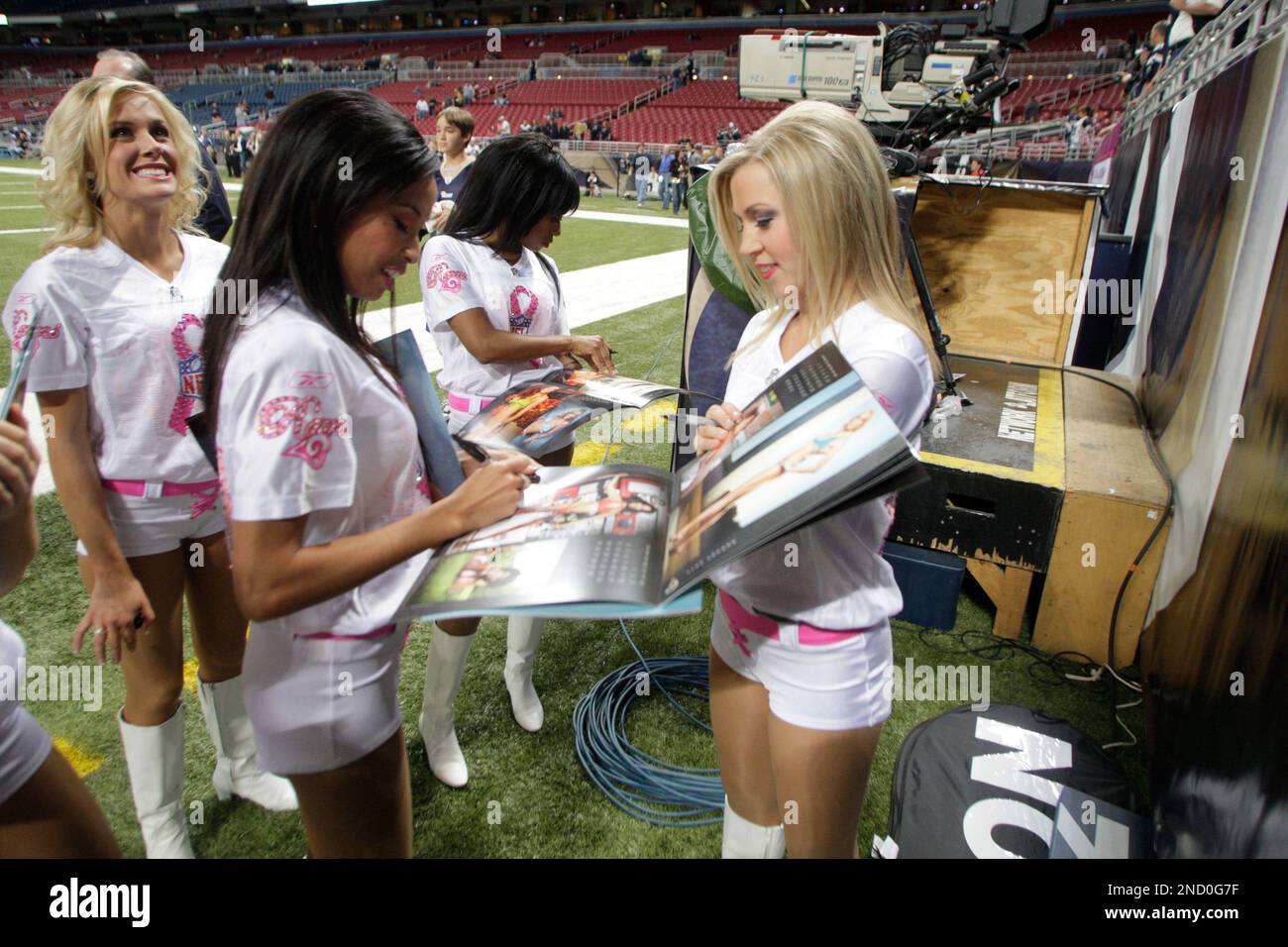 St. Louis Rams cheerleaders sign their swimsuit calendar for a fan