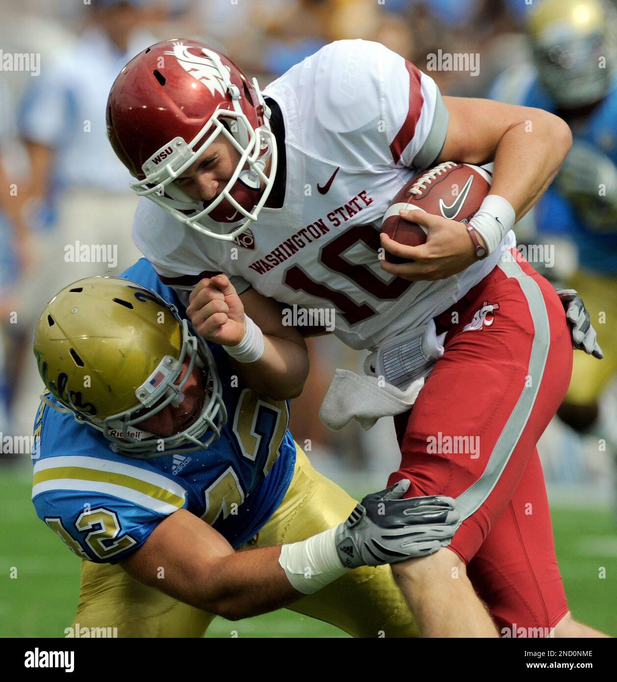 Washington State Cougars quarterback Jeff Tuel,right, is bought down by UCLA Bruins linebacker