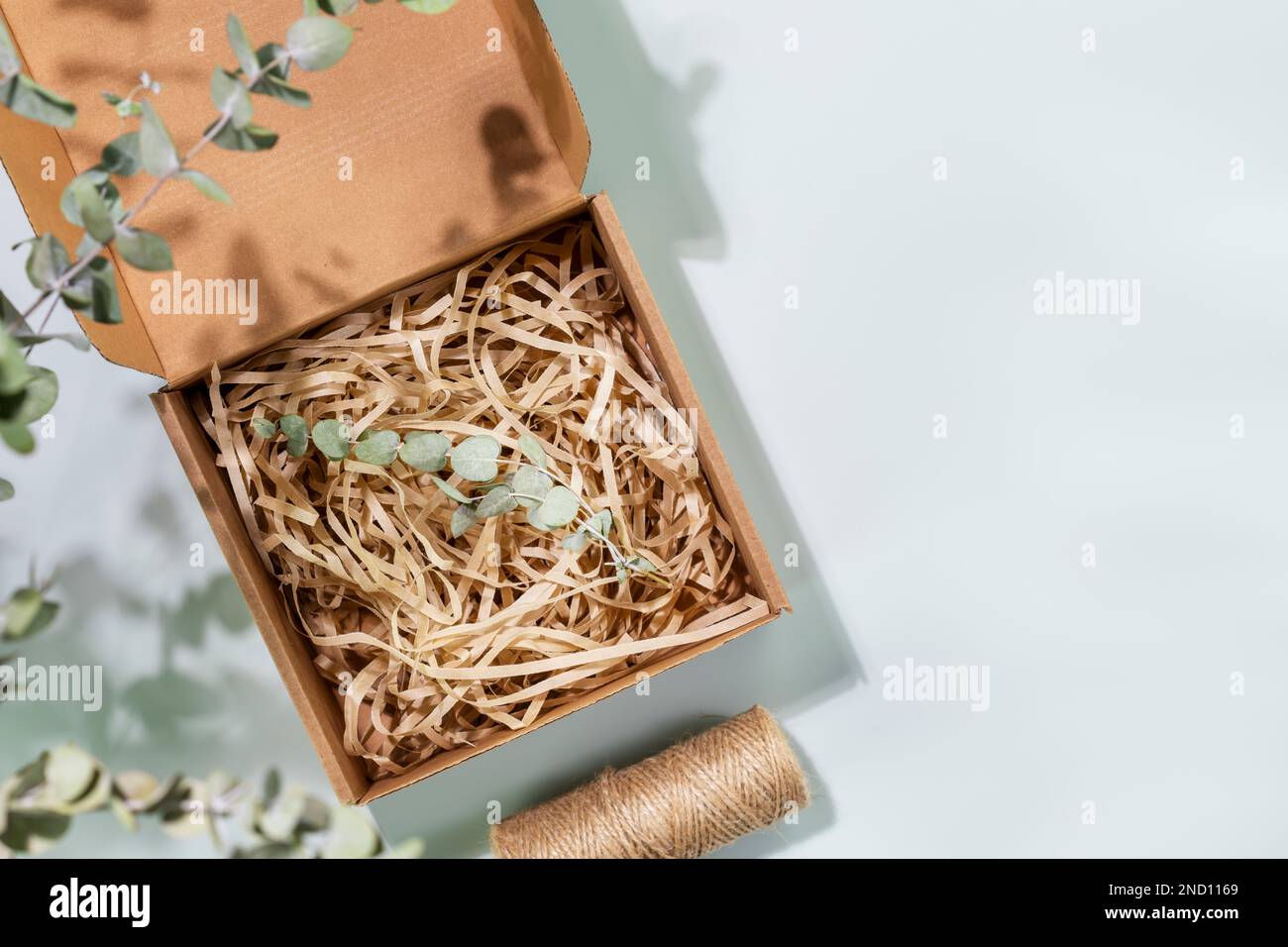 Eco friendly packaging concept. Cardboard box with shredded paper and ...