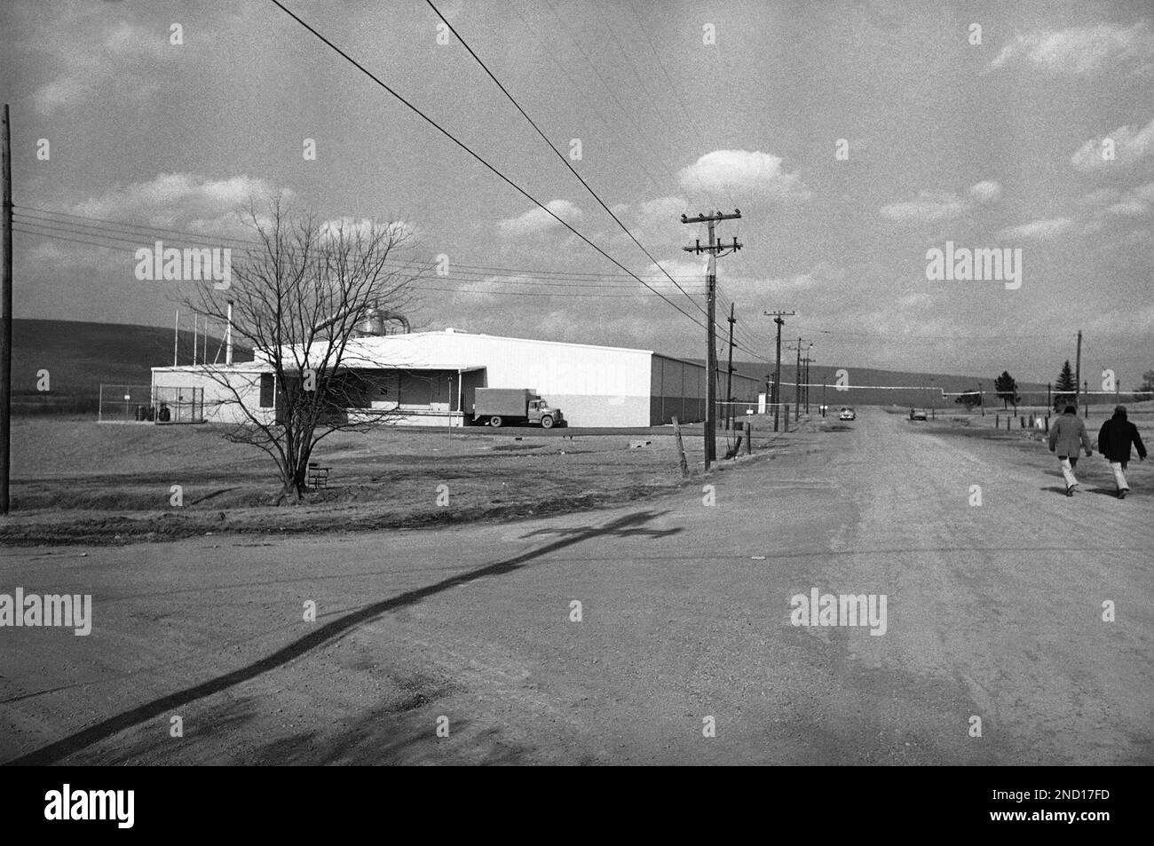 Two unguarded prisoners, right, walk along road inside the minimum
