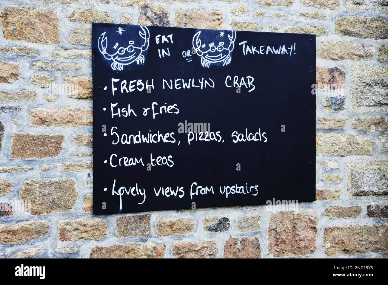 Cafe menu on a stone wall at Marazion.Marazion is the hub village for visiting St. Michael's Mount, Cornwall, UK - John Gollop Stock Photo