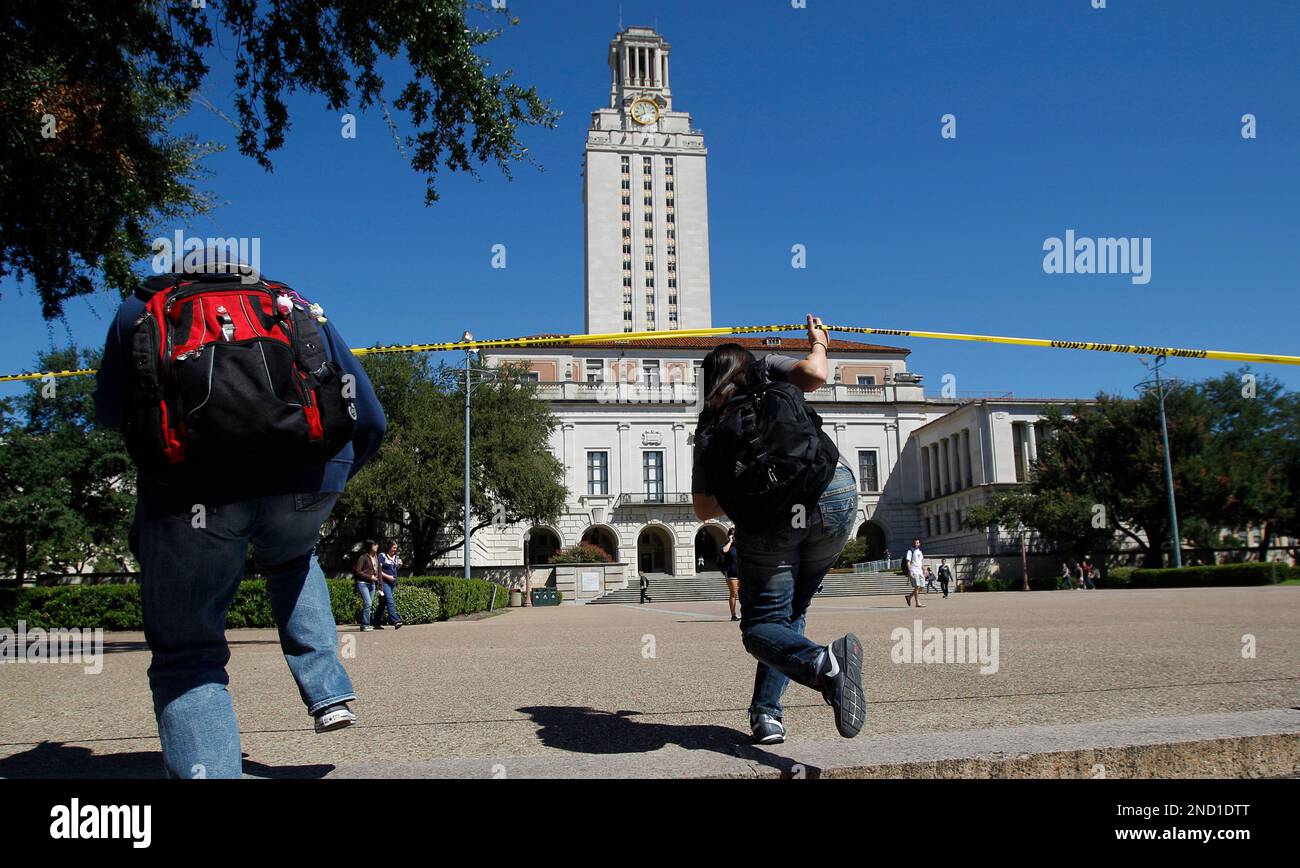 Students walk under a crime scene barrier on the University of Texas ...